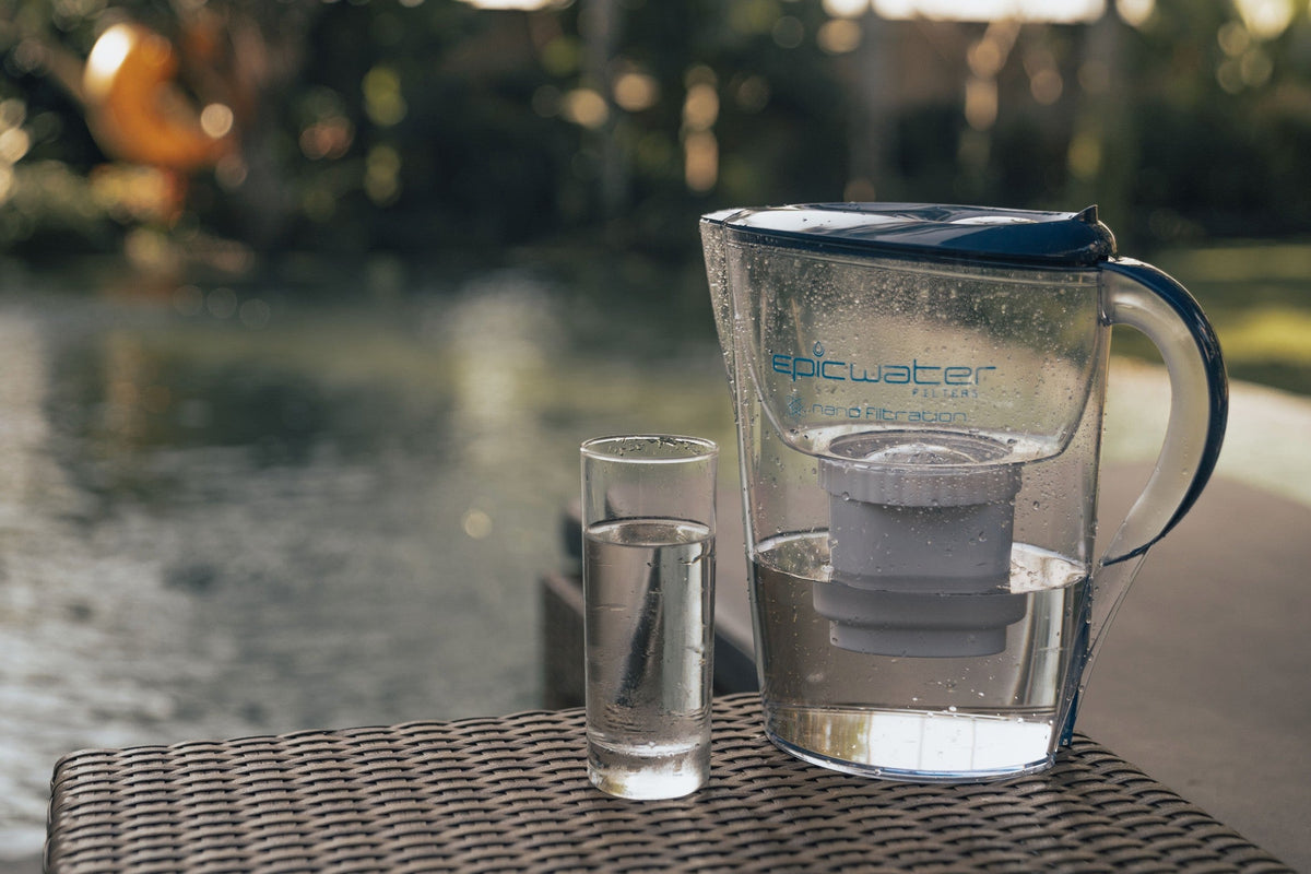 Epic Nano water filter pitcher and a glass of filtered water on an outdoor table