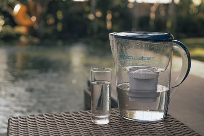 Epic Nano water filter pitcher and a glass of filtered water on an outdoor table